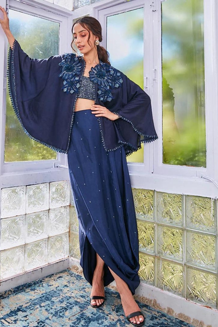 DEEP BLUE DRAPE SKIRT WITH FULLY EMBROIDERED BUSTIER AND CAPER WITH APPLIQUÉ FLOWERS