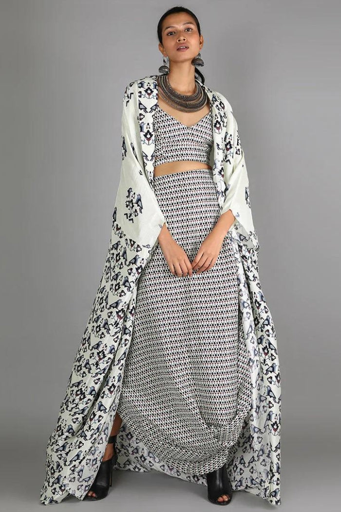 WHITE JAALI PRINT BUSTIER AND DRAPE SKIRT PAIRED WITH WHITE HALF BIRD PRINT AND HALF GEOMETRIC DAMASK PRINT CAPE