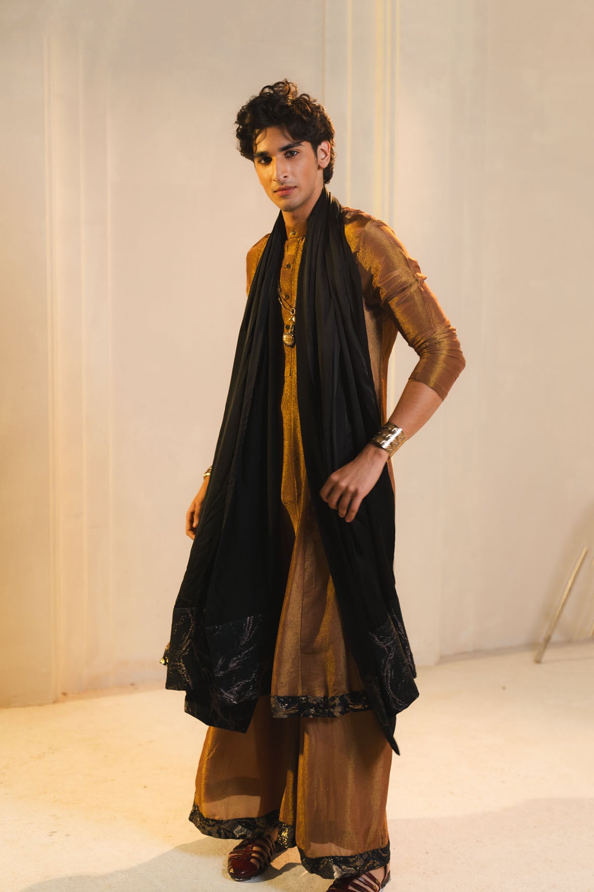 Anarkali Kurta In Gold, Paired With Flared Trousers And A Contrasting Black Dupatta.