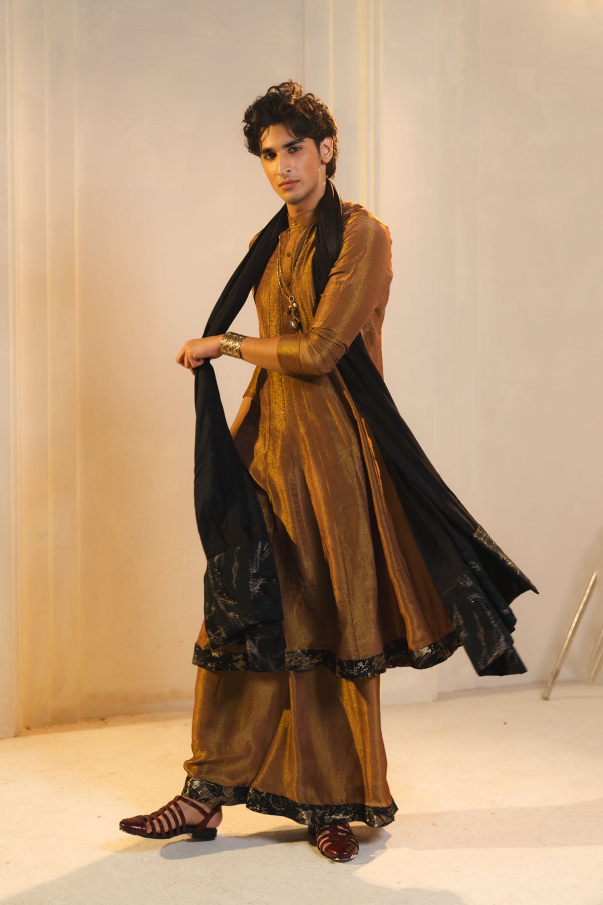 Anarkali Kurta In Gold, Paired With Flared Trousers And A Contrasting Black Dupatta.